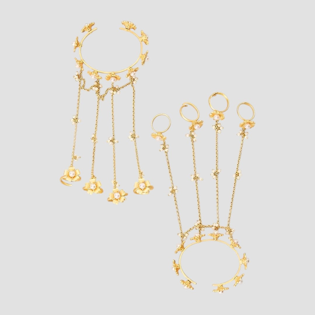 Gold-tone floral pearl hathphool hand harness set with bracelets connected to multiple rings by delicate chains.”