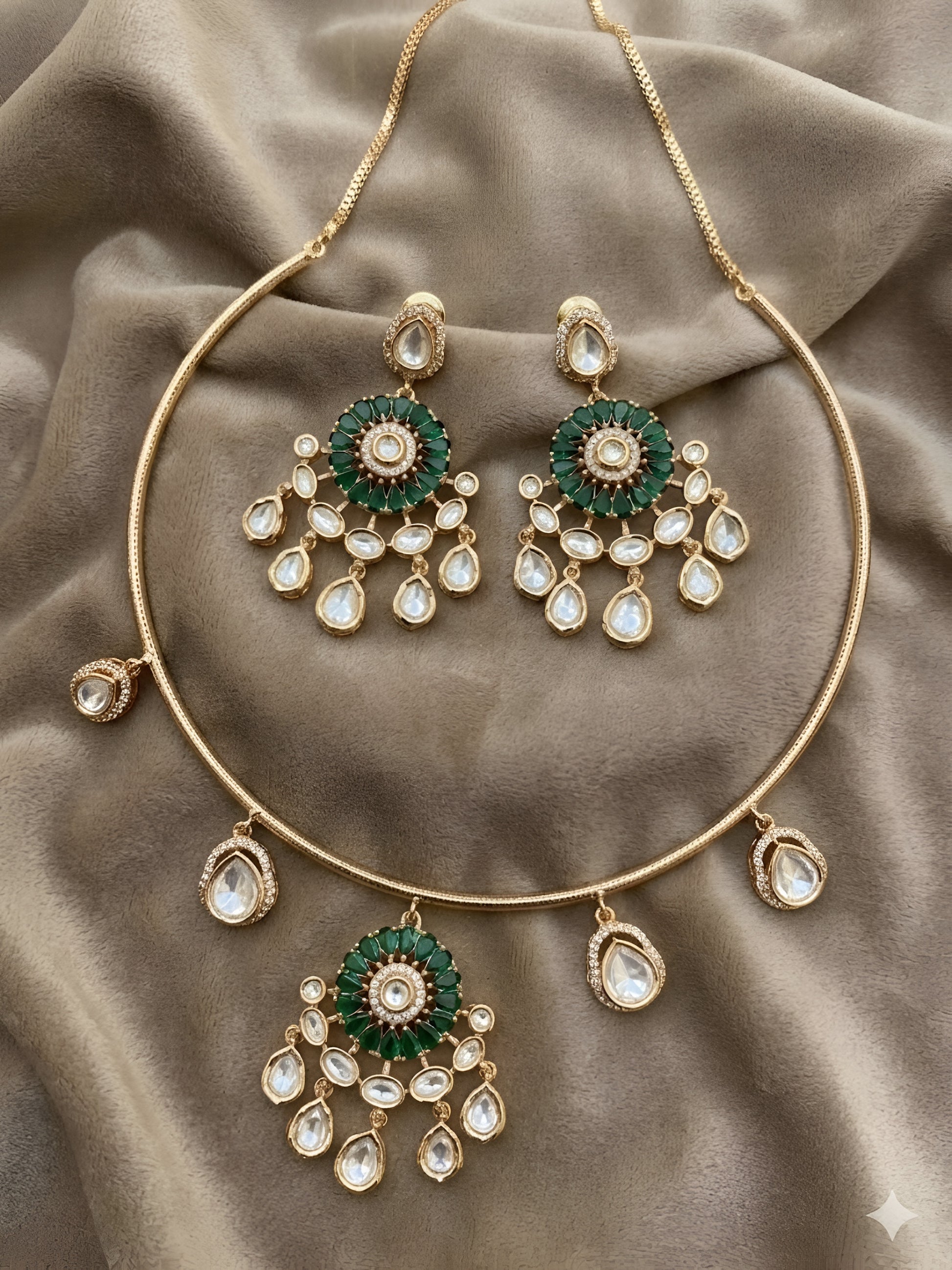 Gold plated choker necklace set with green stones and kundan detailing, featuring matching earrings and teardrop hanging design