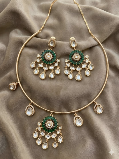 Gold plated choker necklace set with green stones and kundan detailing, featuring matching earrings and teardrop hanging design