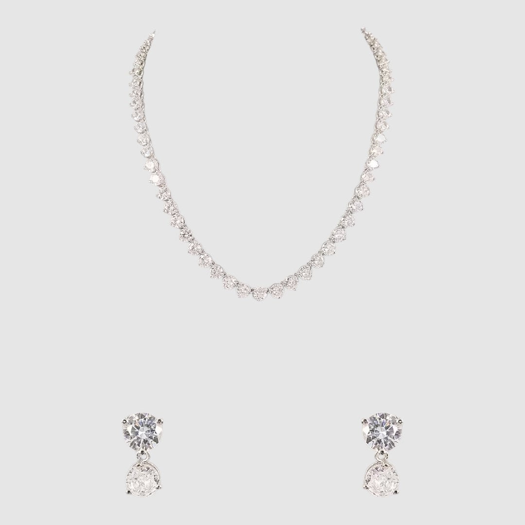 Silver-toned diamond-cut necklace with matching double-stone drop earrings on a light background