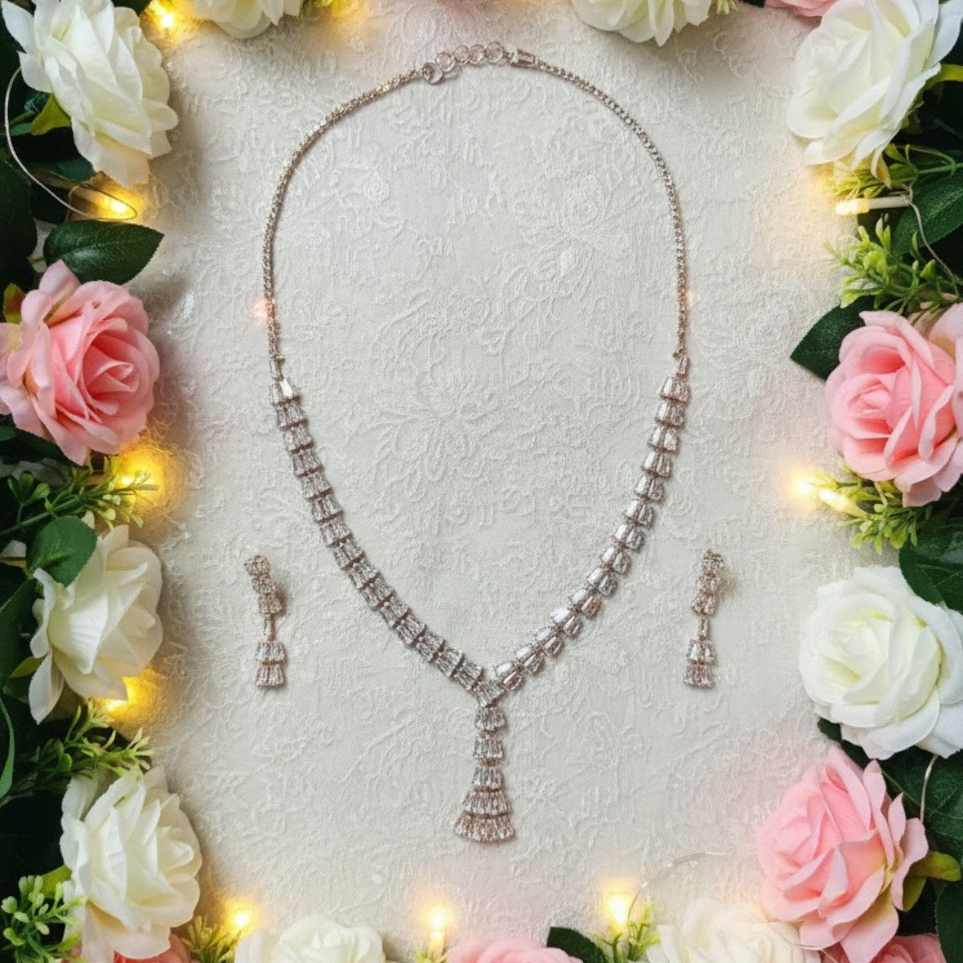 Elegant leaf design American diamond necklace with green stone detailing and matching earrings on red velvet display stand
