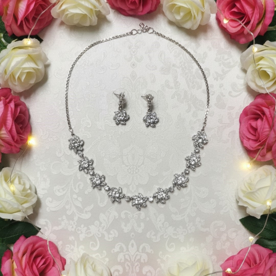 Sparkling floral American diamond necklace with matching earrings displayed on red velvet stand