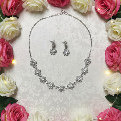 Sparkling floral American diamond necklace with matching earrings displayed on red velvet stand