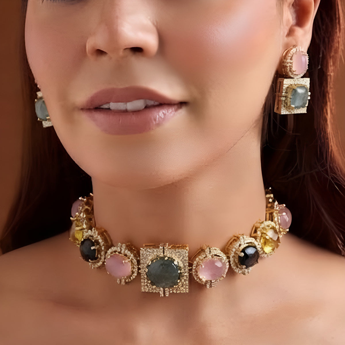 Gold-plated multicolour cabochon choker necklace set with square zircon pavé centre, pink grey and yellow stones and matching two-tier earrings on a display bust