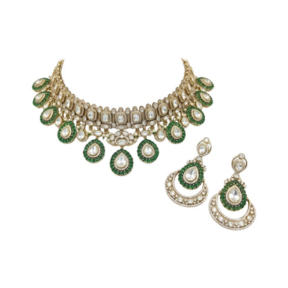 Gold Victorian kundan bridal choker with emerald-green ringed pear drops and matching crescent chandelier earrings on dark green velvet