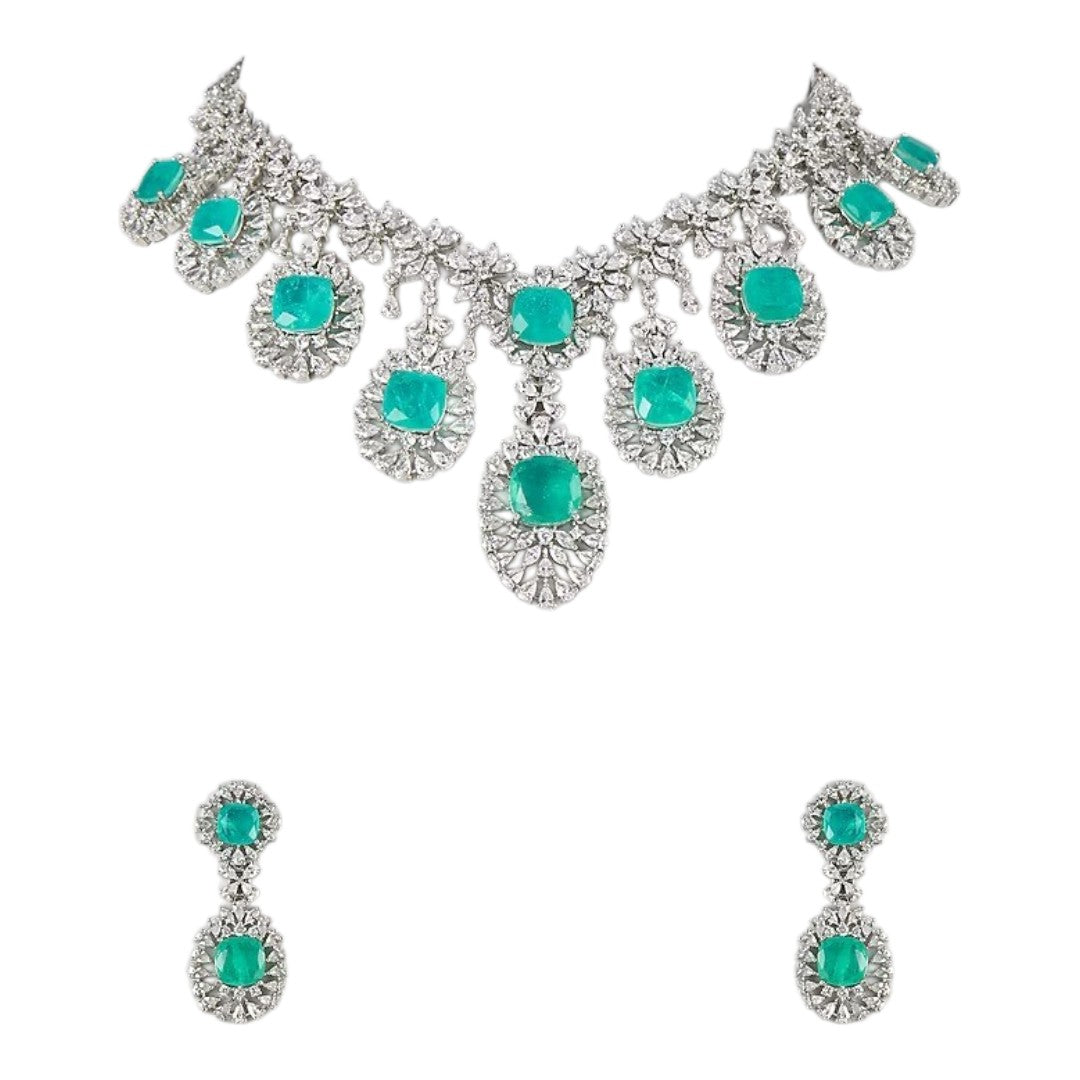 "Silver rhodium-plated multi-tier bridal necklace set with white American diamonds and cushion-cut emerald green stones, paired with matching drop earrings"