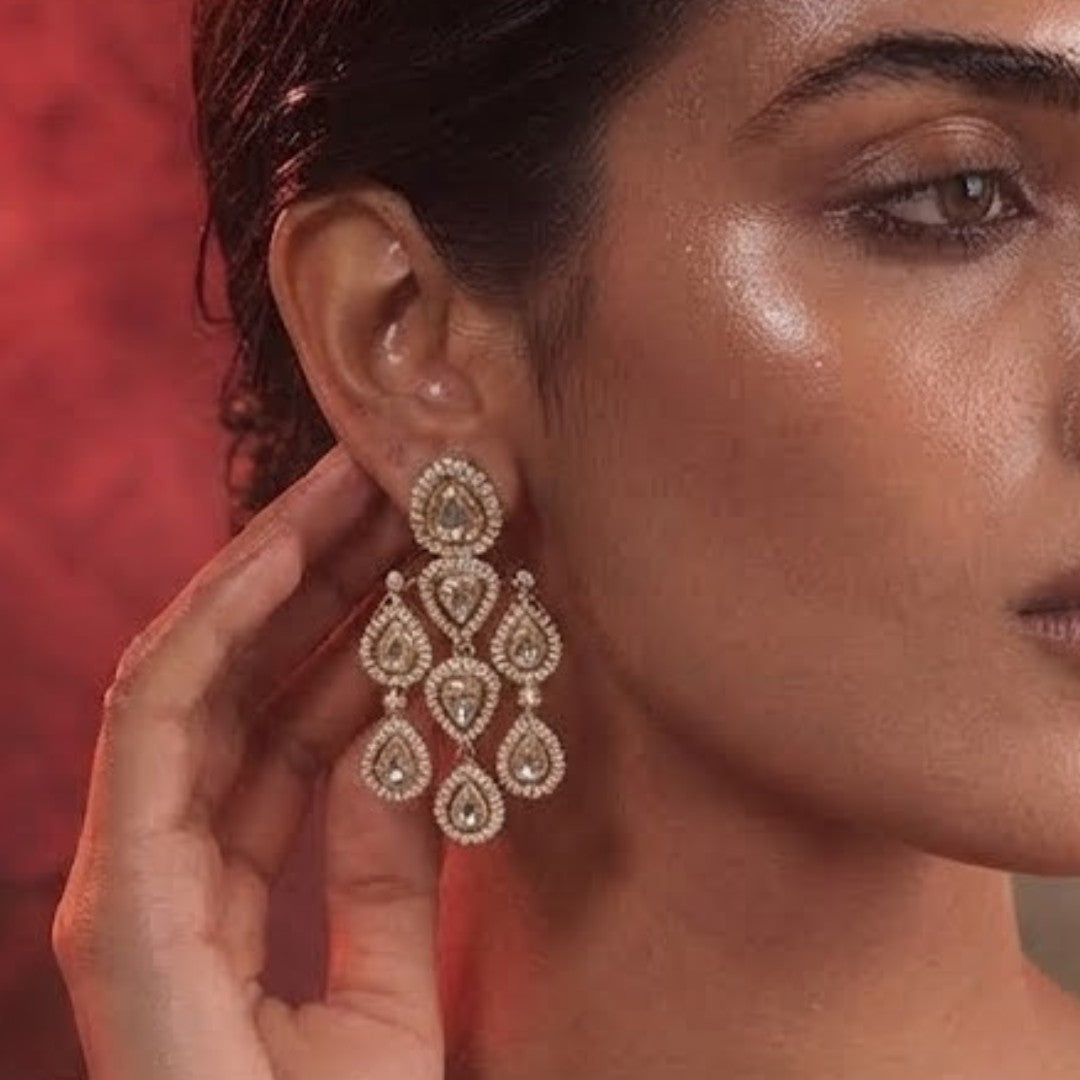 "Gold-plated American Diamond chandelier earrings with multi-tier teardrop CZ clusters, statement party wear earrings on white background"