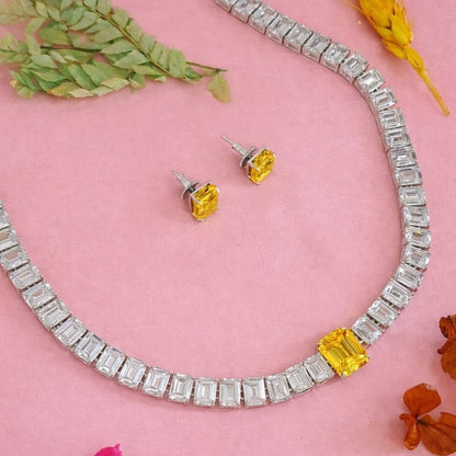 Rhodium American diamond tennis necklace with emerald-cut clear stones, yellow centre stone and matching yellow stud earrings 