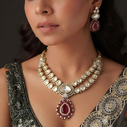 Antique gold two-strand polki kundan necklace with ruby red teardrop pendant on a display bust