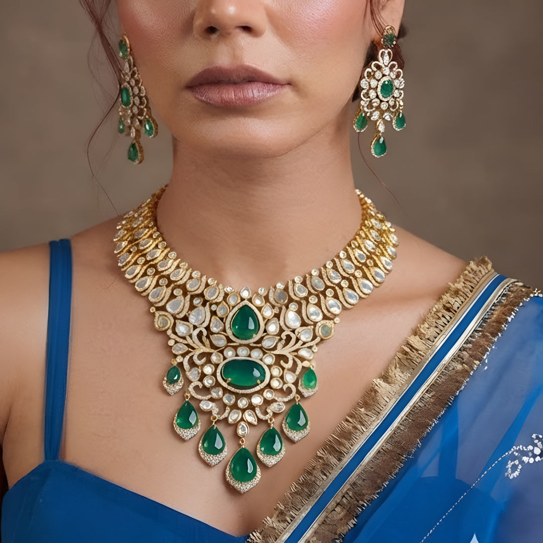 Gold kundan polki bridal necklace set with emerald green pear and oval stones, teardrop drops and matching chandelier earrings