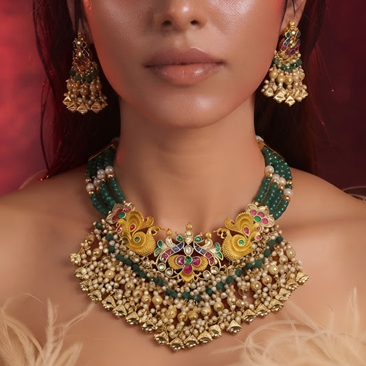 "Antique gold peacock motif necklace and earring set with green beaded strands and pearl drops, traditional temple jewellery on maroon backdrop"