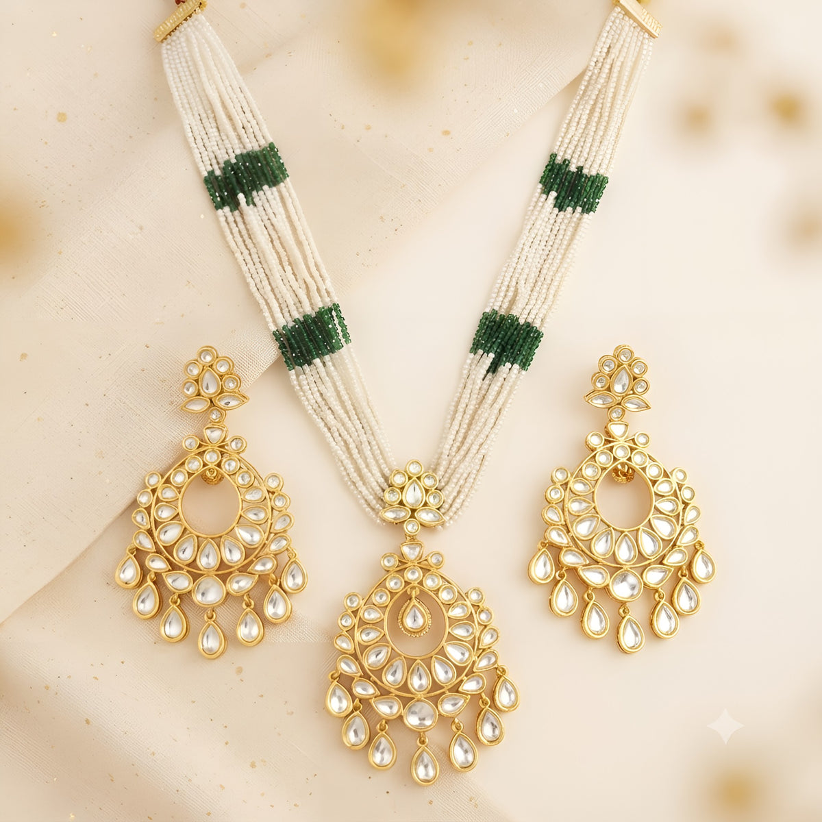 Multi-strand white pearl necklace with green bead bands and gold kundan chandbali pendant on a display bust