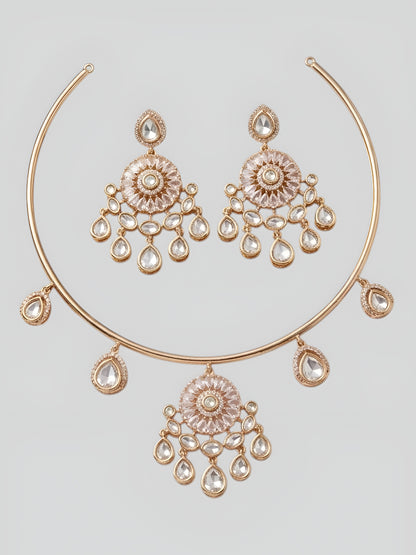 Rose gold plated kundan choker necklace set with crystal teardrop danglers and matching earrings displayed on elegant marble background