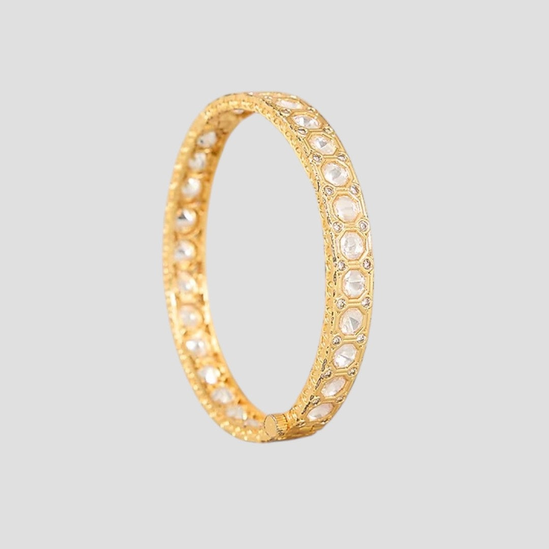 “Pair of gold-plated bangles with circular stone-studded design on a neutral background.”