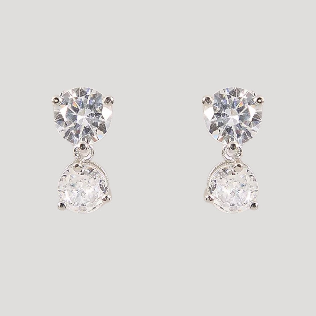 Silver-toned diamond-cut necklace with matching double-stone drop earrings on a light background