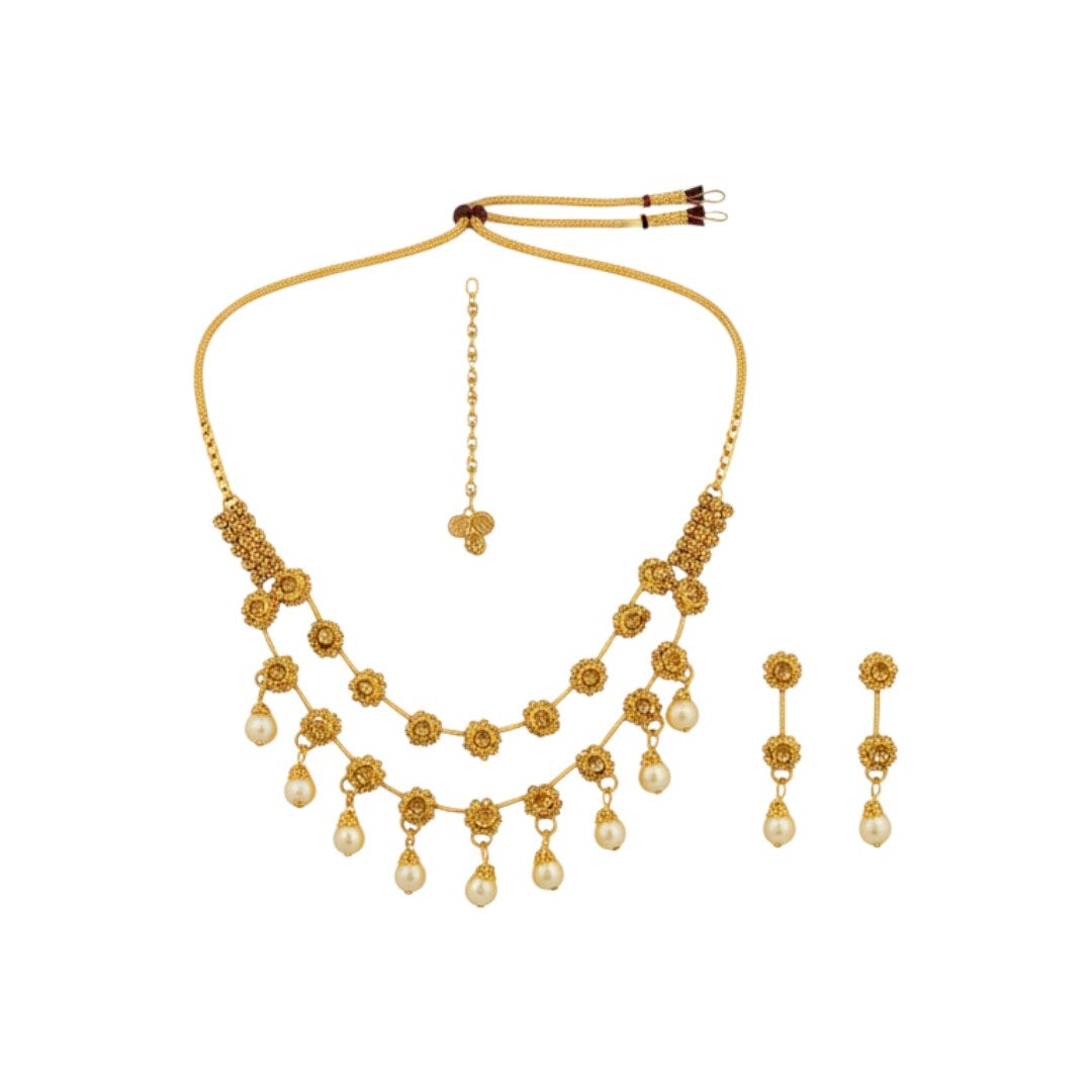 Traditional gold-plated necklace set with floral motifs and matching earrings displayed on red stand