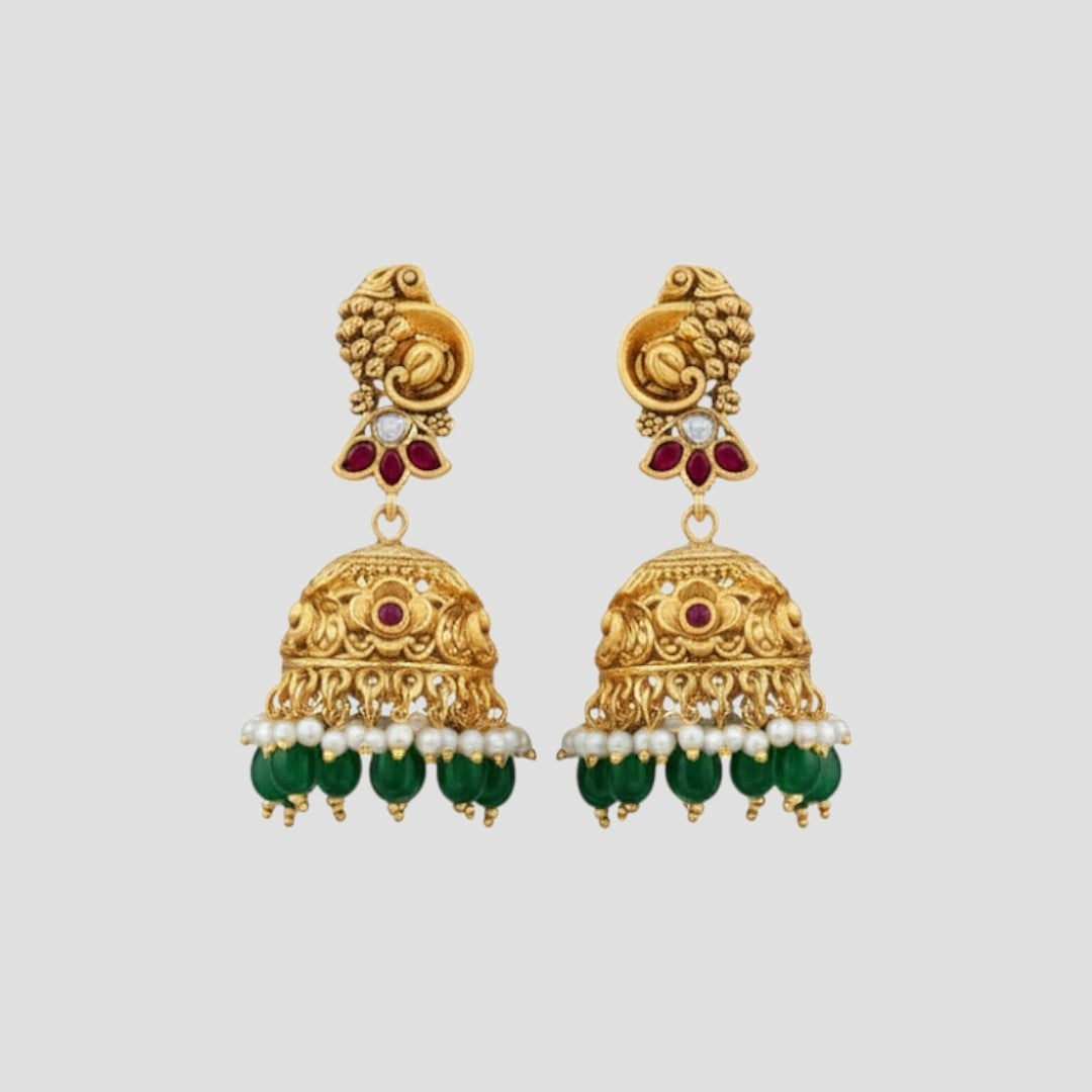 “Gold-plated South Indian temple necklace set with ruby stones, green beads, pearl detailing and matching jhumka earrings.”