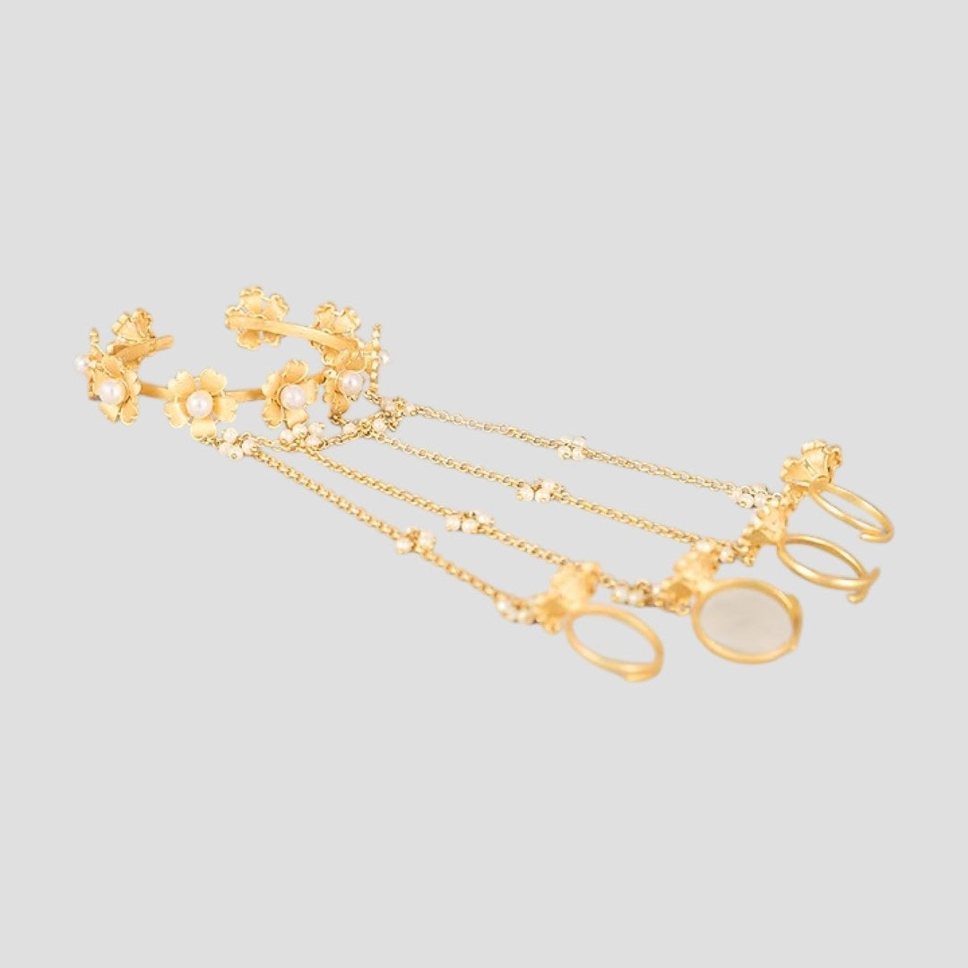Gold-tone floral pearl hathphool hand harness set with bracelets connected to multiple rings by delicate chains.”