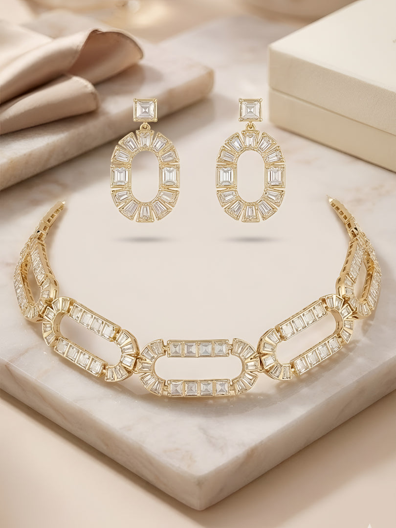 Gold-plated geometric crystal statement necklace set with matching oval drop earrings featuring baguette-cut stones for women.