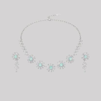 Elegant floral necklace and earrings set with green gemstone and sparkling American diamonds on red display stand