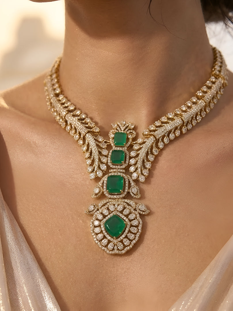 Gold-plated American diamond necklace set with emerald green stones and matching earrings for women, perfect for bridal, wedding, festive, and party wear.