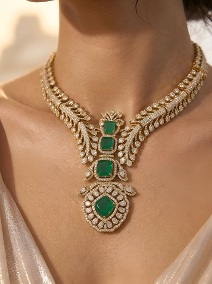 Gold-plated American diamond necklace set with emerald green stones and matching earrings for women, perfect for bridal, wedding, festive, and party wear.