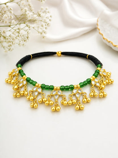 Traditional gold-plated Kundan choker necklace featuring green beads, black thread design, and decorative ghungroo danglers for women.