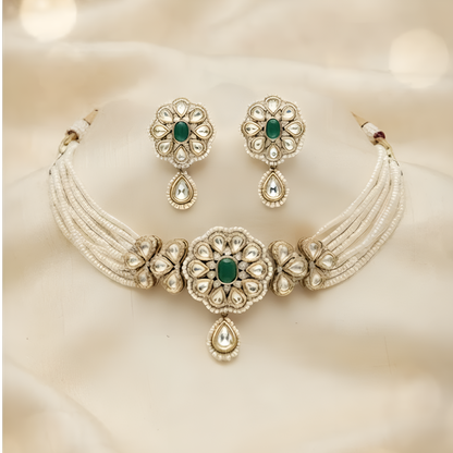 Gold-plated multi-strand pearl choker necklace set with emerald green floral kundan medallion, teardrop pendant and matching stud earrings