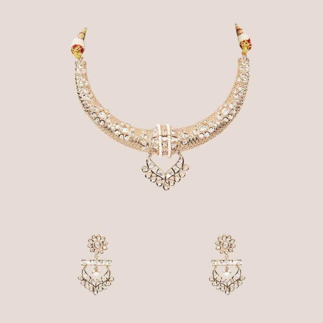 Gold-tone American Diamond designer necklace with textured stone detailing, statement pendant, and matching drop earrings styled on a model.
