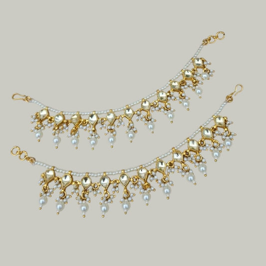 Classic Pearl & Golden Kundan Single Layer Kaan Chain - Auraa Trends - Kaan chain -  - Auraa Trends - Elegant golden Kundan and pearl single - layer Kaan Chain (Ear Chain) with heart - shaped motifs and dangling pearl drops, displayed on a beige fabric background with decorative flowers and seashell.