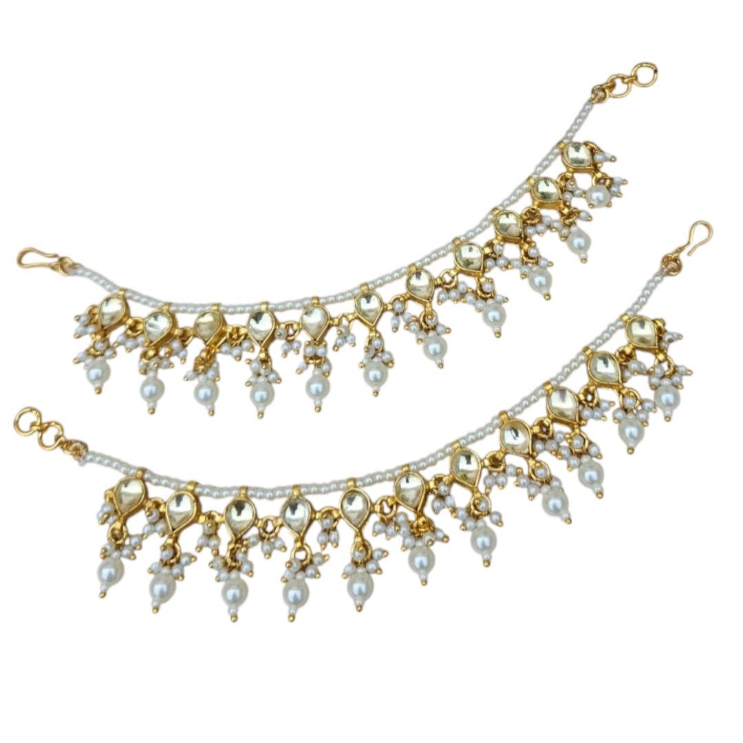 Classic Pearl & Golden Kundan Single Layer Kaan Chain - Auraa Trends - Kaan chain -  - Auraa Trends - Elegant golden Kundan and pearl single - layer Kaan Chain (Ear Chain) with heart - shaped motifs and dangling pearl drops, displayed on a beige fabric background with decorative flowers and seashell.