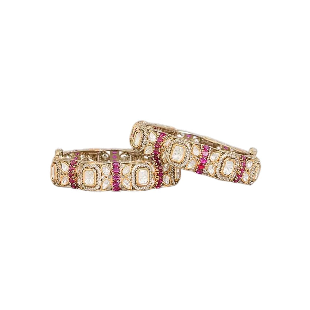 "Set of two gold-toned bangles with white polki stones and ruby-pink stone clusters, traditional Indian bridal jewelry"