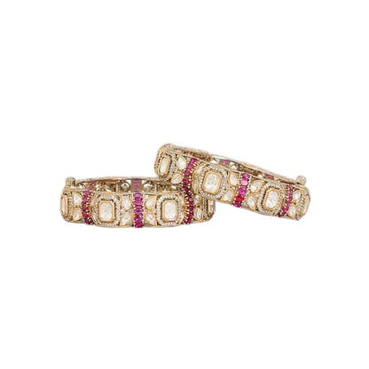 "Set of two gold-toned bangles with white polki stones and ruby-pink stone clusters, traditional Indian bridal jewelry"