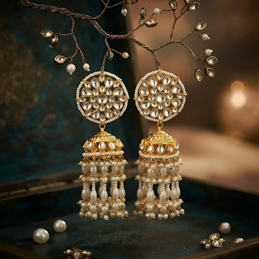 Antique gold Kundan jhumka earrings with floral stud and pearl tassel drops for women.