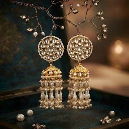 Antique gold Kundan jhumka earrings with floral stud and pearl tassel drops for women.