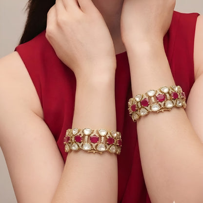 Pair of gold-finish wide kada bangles with ruby-pink emerald-cut stones, polki-style clear pear stones, and American diamond detailing
