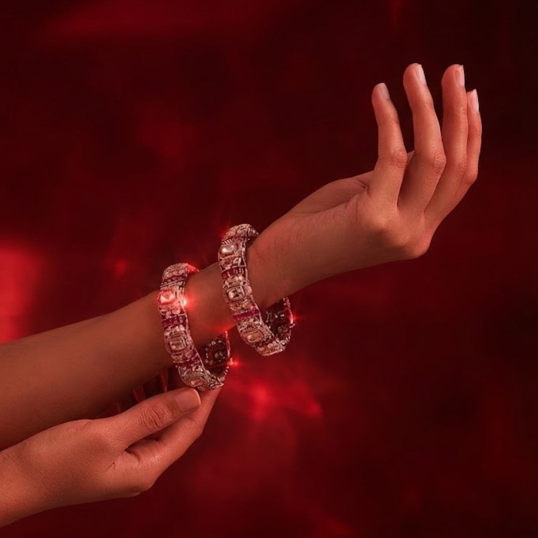 "Set of two gold-toned bangles with white polki stones and ruby-pink stone clusters, traditional Indian bridal jewelry"