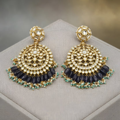 "Gold polish Kundan chandbali earrings with navy blue iolite beads and turquoise pearl fringe, displayed on jewelry stand"