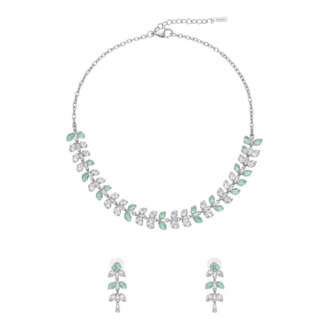 Silver necklace and matching earrings set with green and clear crystals displayed on a red velvet jewelry stand, perfect for weddings and formal events.