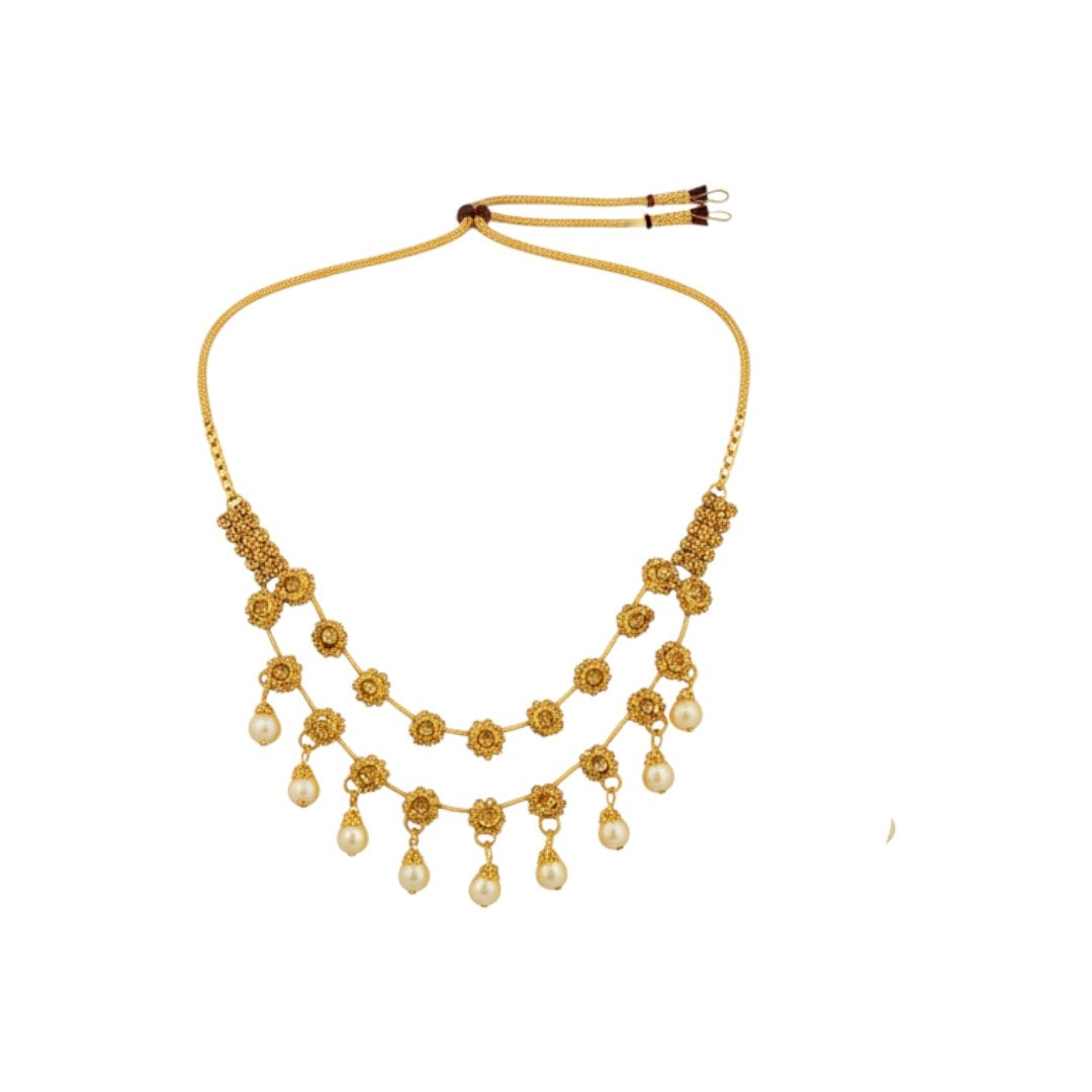 Traditional gold-plated necklace set with floral motifs and matching earrings displayed on red stand