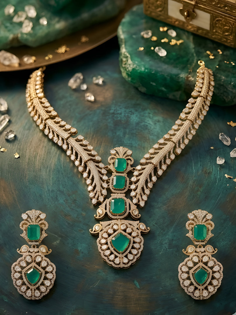 Gold-plated American diamond necklace set with emerald green stones and matching earrings for women, perfect for bridal, wedding, festive, and party wear.