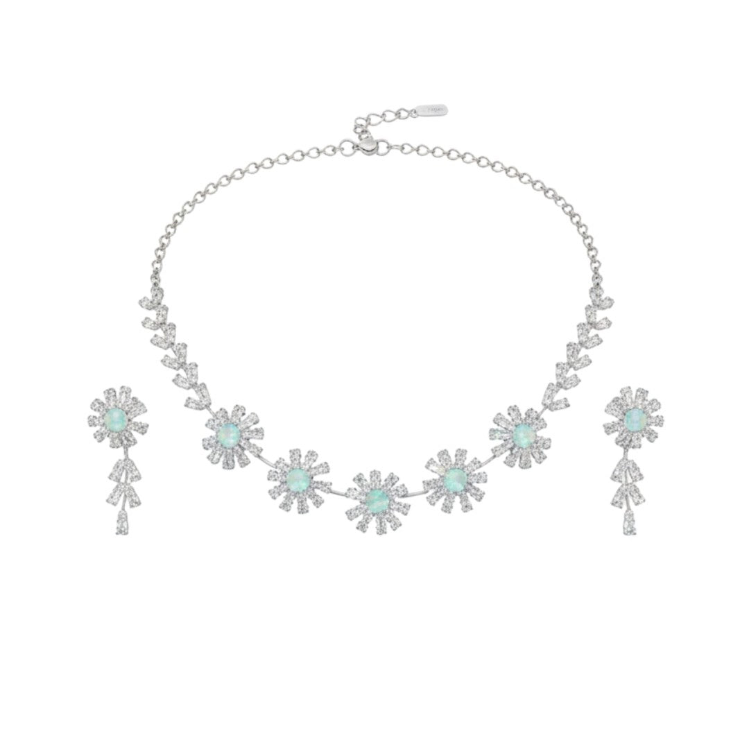 Elegant floral necklace and earrings set with green gemstone and sparkling American diamonds on red display stand