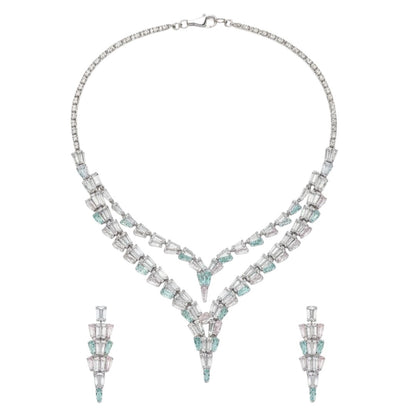 Elegant American Diamond necklace set displayed on a red velvet stand, featuring a double-layered V-shaped necklace with matching earrings, perfect for bridal or party wear.
