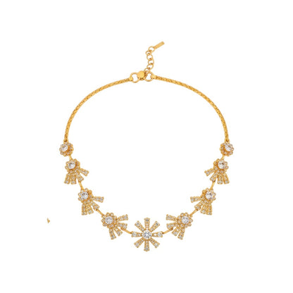 "Gold-plated floral necklace set with stone-studded motifs and matching earrings displayed on black stand – ideal for weddings and festive wear."