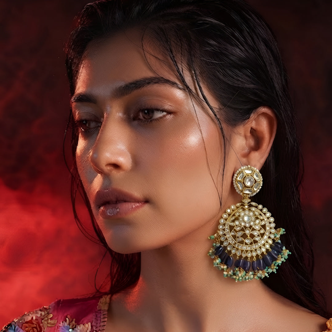 "Gold polish Kundan chandbali earrings with navy blue iolite beads and turquoise pearl fringe, displayed on jewelry stand"