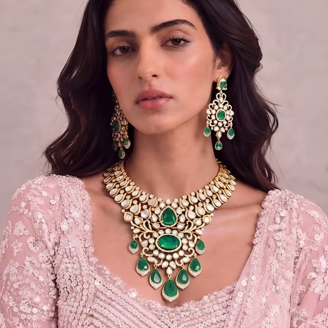 Gold kundan polki bridal necklace set with emerald green pear and oval stones, teardrop drops and matching chandelier earrings