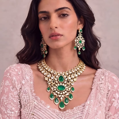 Gold kundan polki bridal necklace set with emerald green pear and oval stones, teardrop drops and matching chandelier earrings