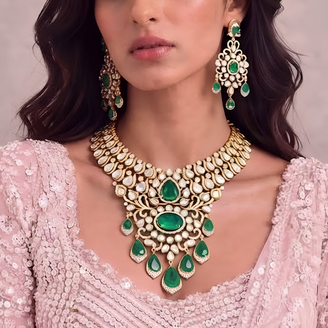 Gold kundan polki bridal necklace set with emerald green pear and oval stones, teardrop drops and matching chandelier earrings