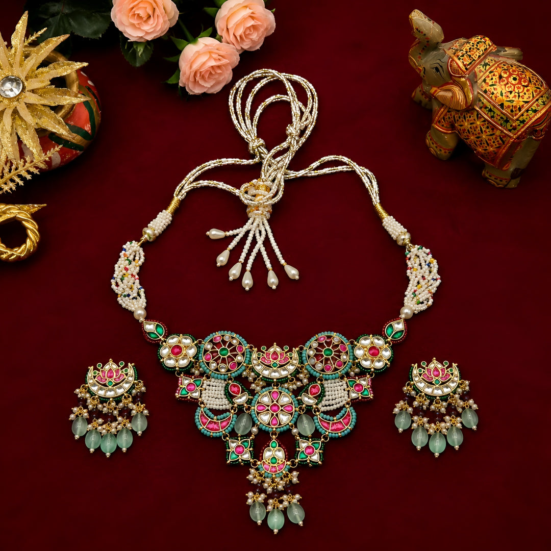 "Antique gold multicolor Kundan necklace and earring set with turquoise pink meenakari medallions, pearl tassel closure and mint bead drops, traditional jewellery on maroon backdrop"