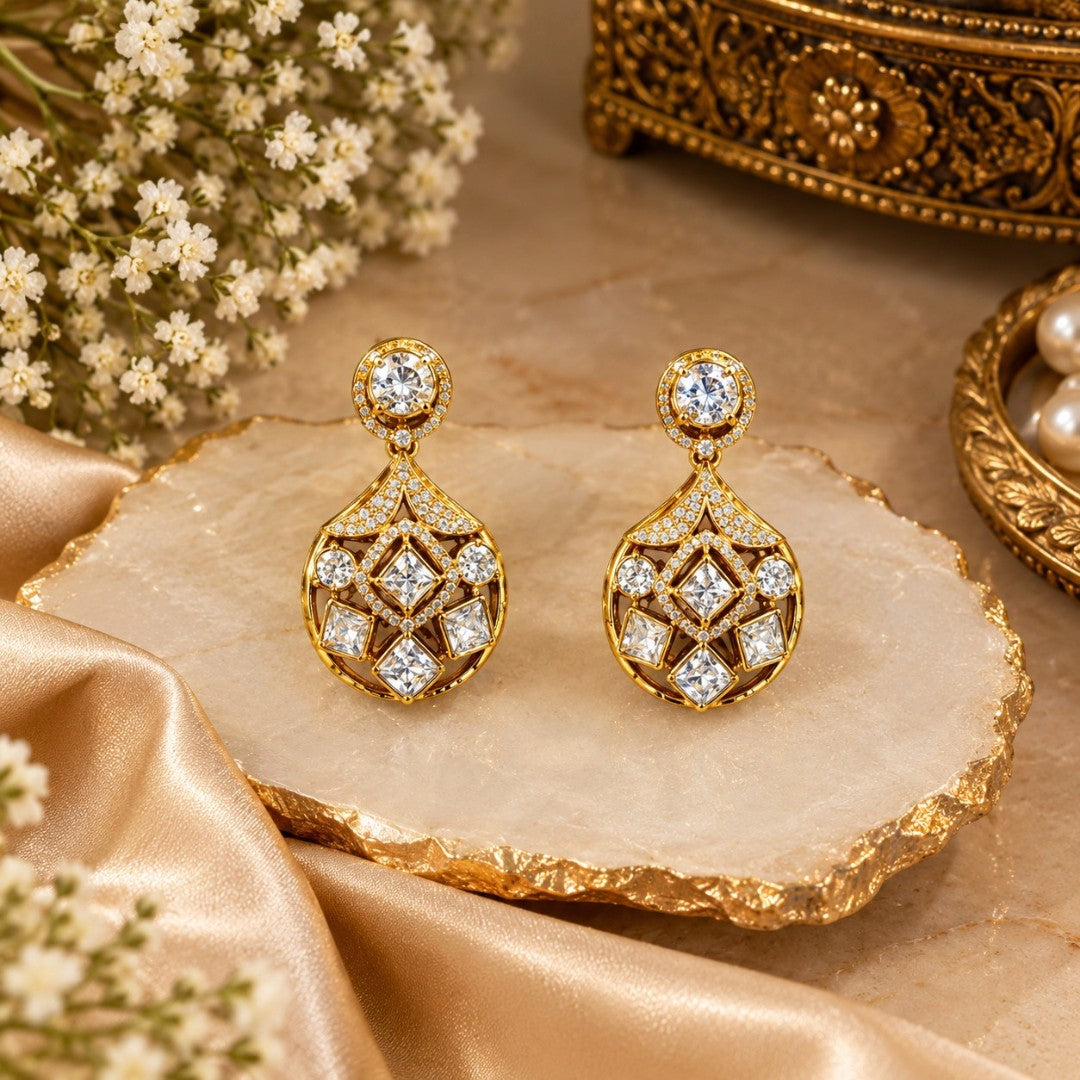 Gold-plated kundan style drop earrings with round halo stud, pavé fan bridge and open teardrop body set with square and round clear zircon stones